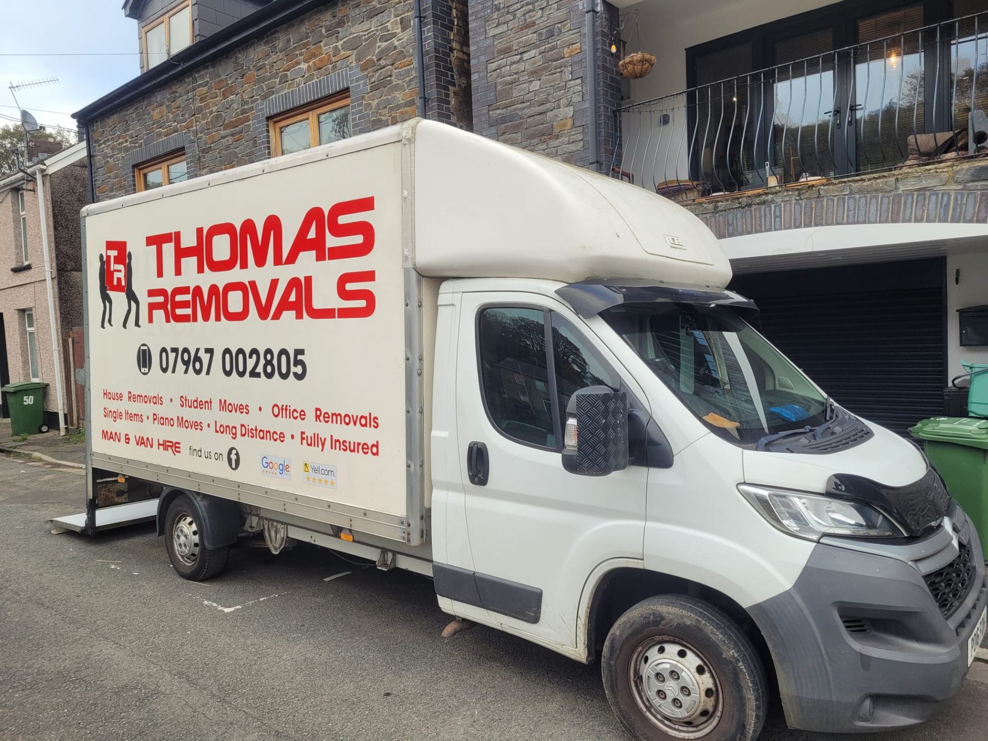 Thomas Removals van outside a stone house in a Welsh valley