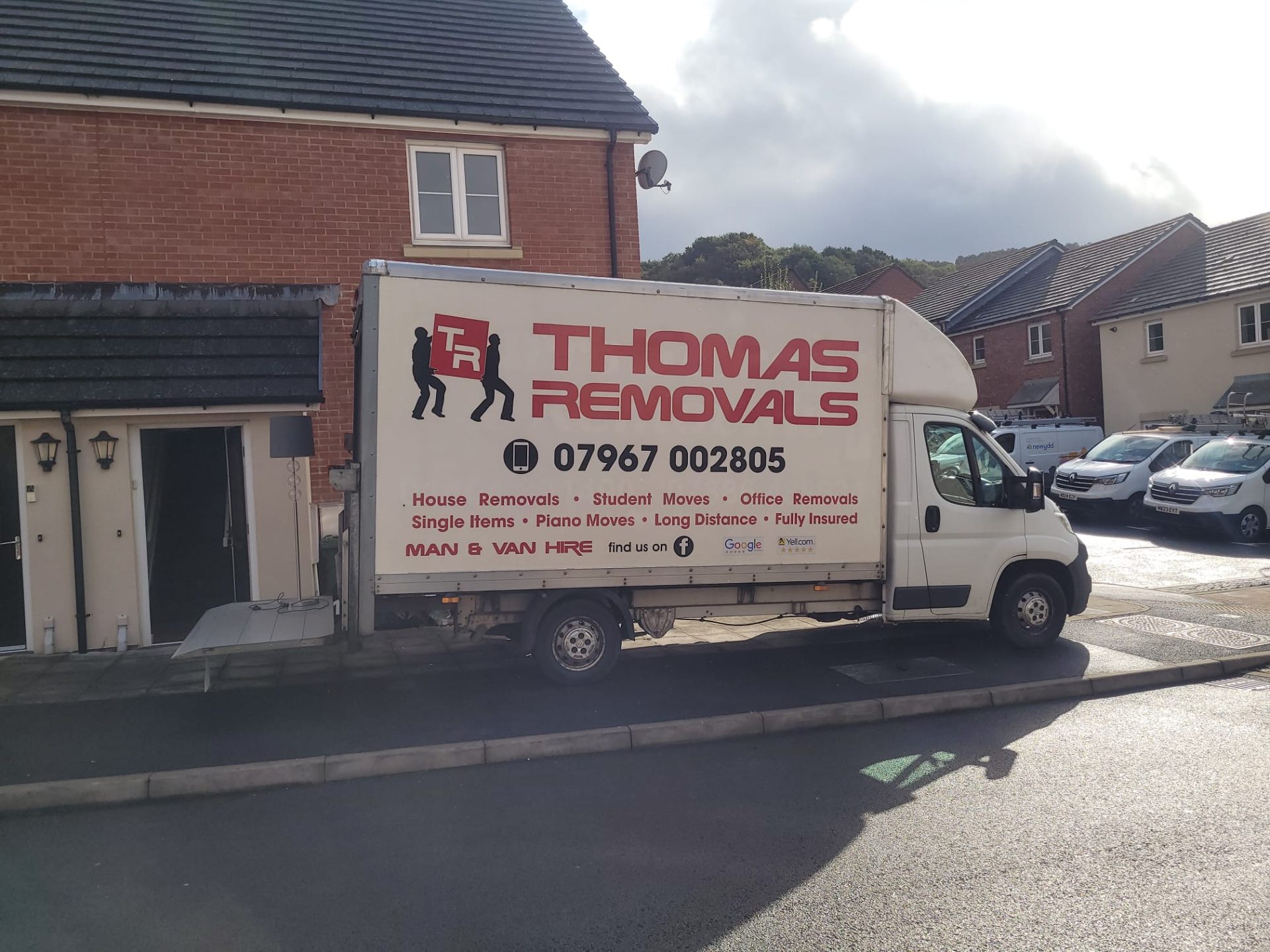 Thomas Removals van on a residential street in Rhondda Cynon Taff